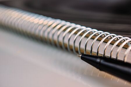 Black pen and metal spiral notepad. Business concept.