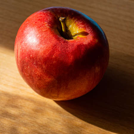 Red apple lies on an oak board. Summer season.の写真素材