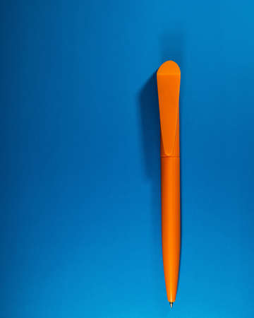 orange plastic pen lies on a blue background. Web banner. Business concept.の写真素材