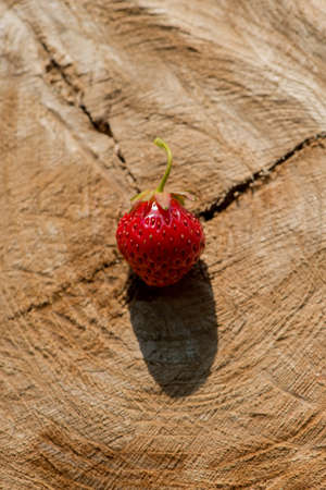 strawberry berry lies on a wooden table surface in the open air. Summer harvest.の写真素材
