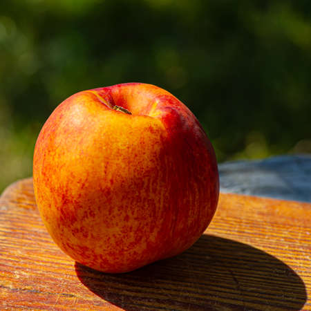 fruit of a red ripe peach lies on a wooden board. Cooking food.