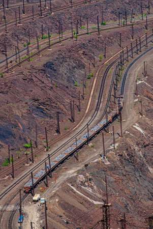 Open pit iron ore mining. Loading of mined ore and delivery by rail and dump trucks. Ukraine....