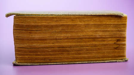An old closed book lies on a pink background. Web banner.
