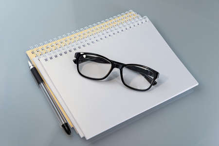 stack of notebooks and glasses are on the table. Business concept. Cover. Background for text.の写真素材