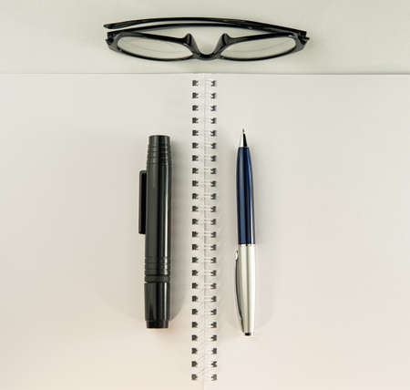 pages of an open notebook pens and glasses lie on the table. Business concept. Cover. Background for...