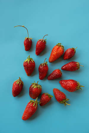 fresh strawberries lie on a blue table surface. Summer season. Cover.
