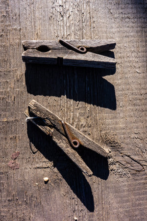 pair of wooden old clothespins lie on a wooden table and shade. Cover.Web banner.の写真素材