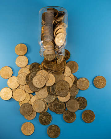 inverted glass jar with coins and coins lying around. Business concept.の写真素材