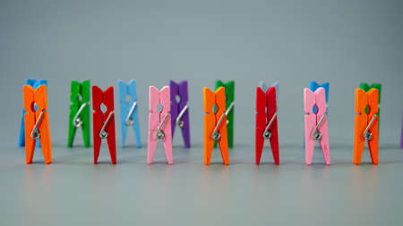 Multi-colored clothespins are in a row on a gray background. Business concept. Cover. Web banner.