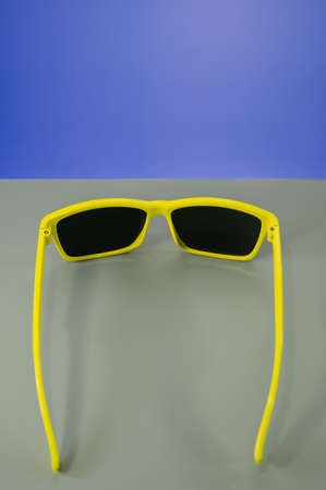 Glasses in yellow frames on a combined background of gray and blue. Business concept. Cover.の写真素材