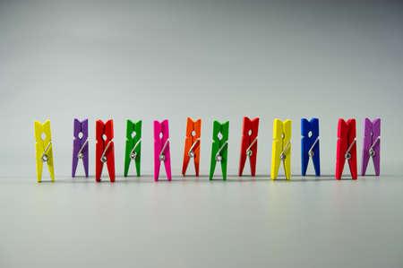 Multi-colored clothespins are in a row on a gray background. Business concept. Cover. Web banner.の写真素材