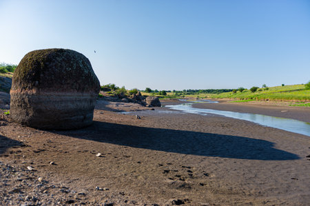 granite boulder on the bank of a stream on a sunny day. Summer season, June. Ukraine. Europe. Web...