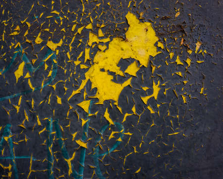 Metal surface covered with old decaying paint and rust. Paint colors - gray, black, yellow. Background for design.の写真素材