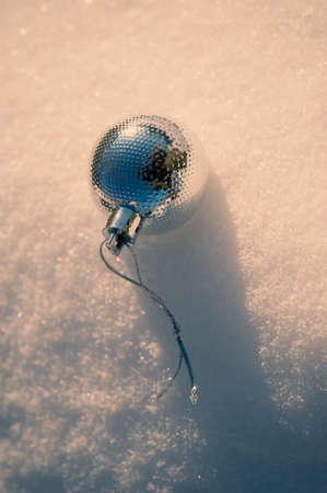 Silver ball with a rope on the snow. Winter season. Cover. Background for design.の写真素材