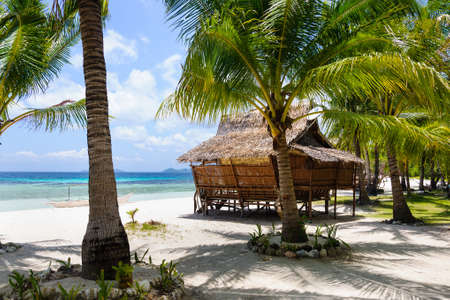 Small hut on the white sand beach near the azur sea