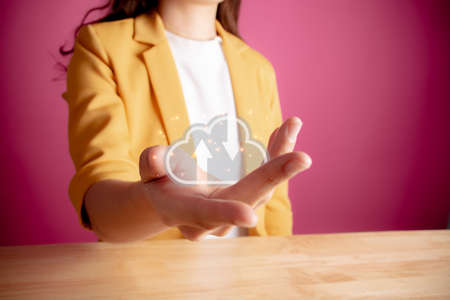 Young woman in yellow suite holding icon cloud computing network and data information in hand. Cloud...