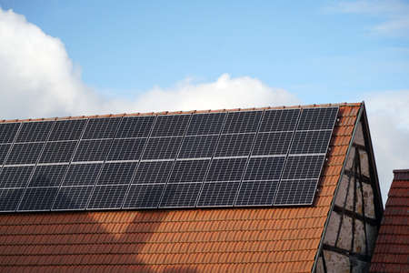 Solar cells on the roof of an old half-timbered barn. Electricity production in the village