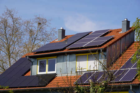 Solar thermal and photovoltaic modules on a residential building roof and on the large dormer window