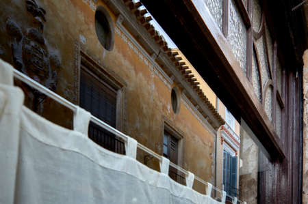 detail of the reflection in a window of old and deteriorated houses of a small townの写真素材