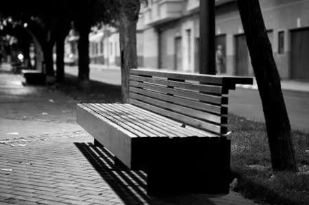 detail of a wooden bench on a walk in a street in winter in black and whiteの写真素材