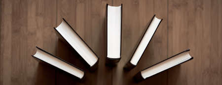 detail of a set of books stacked and distributed on the wooden floorの写真素材