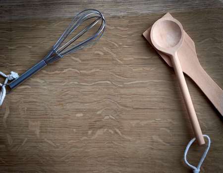 detail of some pastry utensils, spoons, pastry beater, on wooden kitchen table