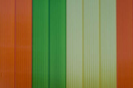 detail of some orange, green and yellow stripes on the wall of a buildingの写真素材