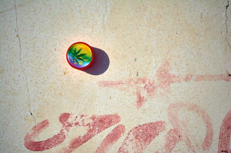 detail of marijuana box abandoned in a bank with a red graffitiの写真素材