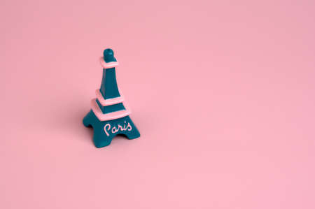 detail of the paris eiffel tower in minimalist format in blue, green and pink on a plain pink backgroundの写真素材