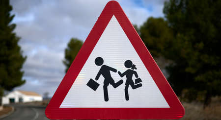 detail of a triangular traffic sign with red border and white background representing the passage of children to the school.の写真素材