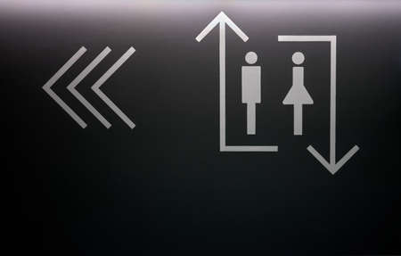 detail of a white sign painted on a wall indicating where the elevators are located