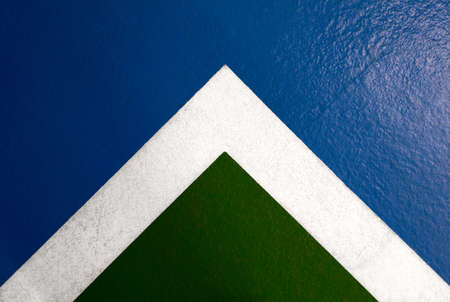 detail of a white marking on a blue and green ground in a parking lotの写真素材