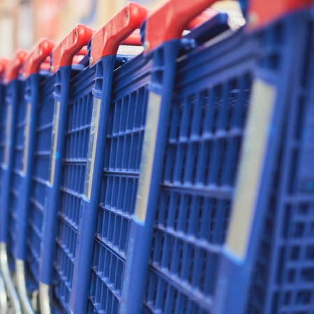 detail of a row of blue and red shopping carts at a shopping mallの写真素材