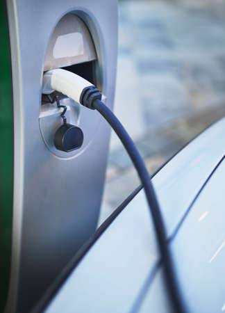detail of an electric car recharging plug connected to a public chargerの写真素材