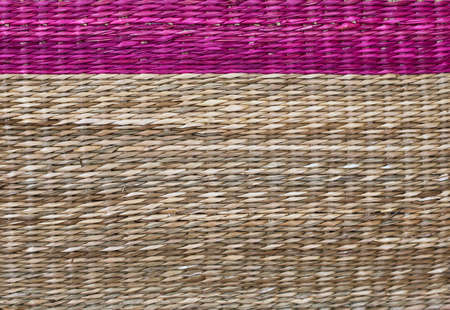 detail of a wicker basket with a rose-colored top and the rest in natural colorの写真素材