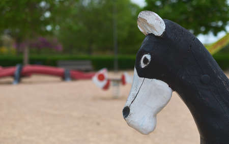 detail of a horse's head from a swing in a public parkの写真素材