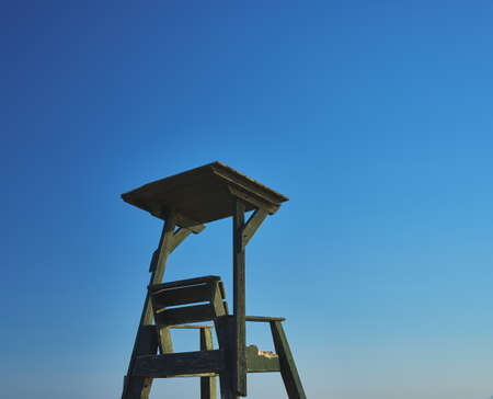 detail of a wooden lifeguard's chair on a beach with blue skyの写真素材