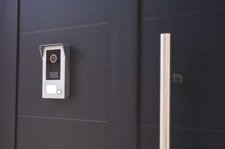 detail of an entrance door to a house with a doorbell with camera