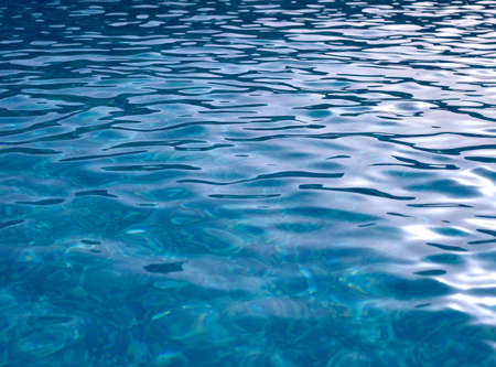 detail of a blue ceramic mosaic tile in a pool with water