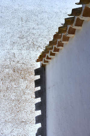 detail of shadows of a roof eave on a wall