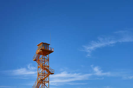 detail of an orange metal fire lookout tower with a blue skyの写真素材