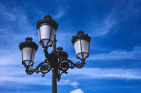 detail of a forged four armed lantern on a blue skyの写真素材