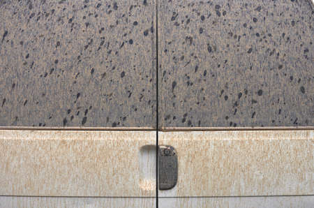 detail of the rear door of a van dirty by the rain with mud