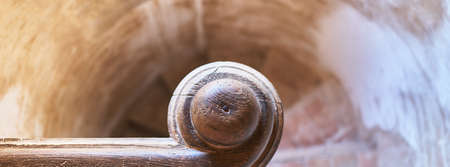 detail of a top view of a stone spiral staircase with a wooden handrailの写真素材
