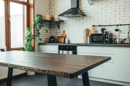 Modern minimalist kitchen with rustic wooden table, white cabinets, black appliances, and airy natural light. Perfect blend of style and functionality.の素材