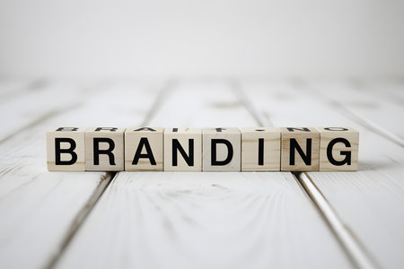 Close-up of 'BRANDING' in white wooden blocks on a light background, emphasizing minimalism and elegance for business or marketing themes.の素材