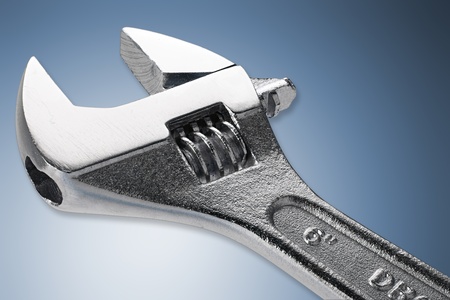 adjustable spanner in front of blue white backgroundの写真素材