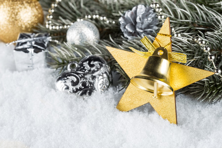 fir branch with golden silver christmas decorations and snowの写真素材
