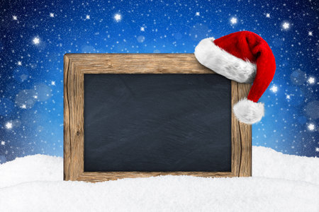 blackboard with santa hat in snowの写真素材