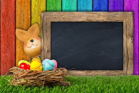 easter bunny with chalkboard on colorful backgroundの写真素材